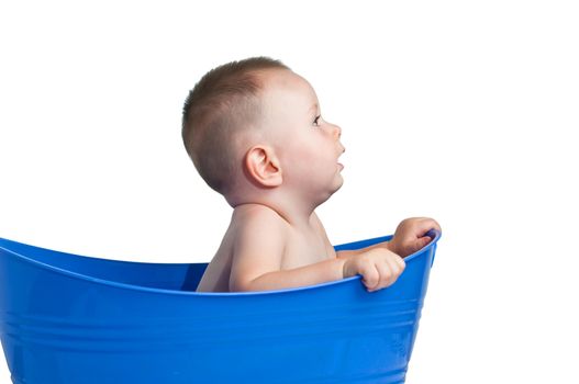 Cute baby in plastic tub looking to the front. Isolated with a clipping path.