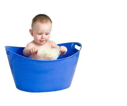A baby boy playing in a plastic laundry basket