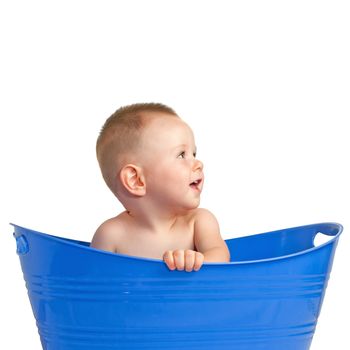 Happy baby boy having fun in the empty laundry basket. Isolated on a white background