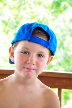 Handsome little boy in summer wearing a reversed cap.