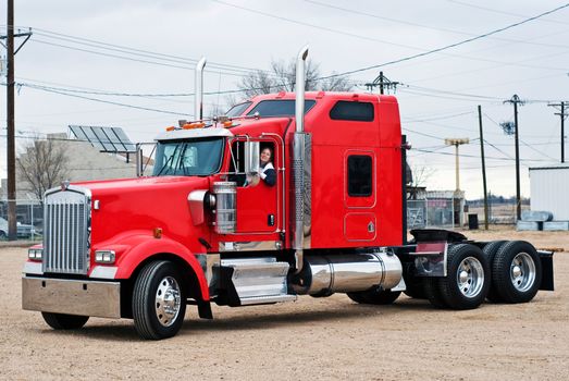 Smiling woman driving a bob-tail big truck.