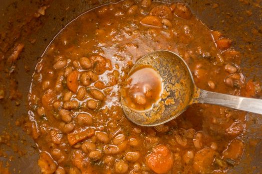 Bean soup into the pot with a ladle
