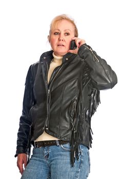 Attractive adult woman in a leather jacket talking on a cellphone. Isolated on a white background.