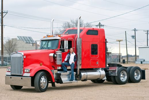 A pretty woman prepares to pre-trip inspect her truck.