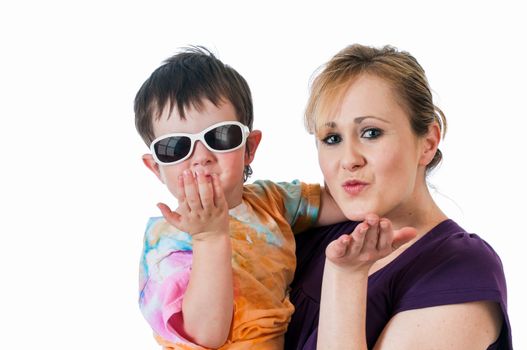 Pretty young woman holding a three year old boy blowing kisses.