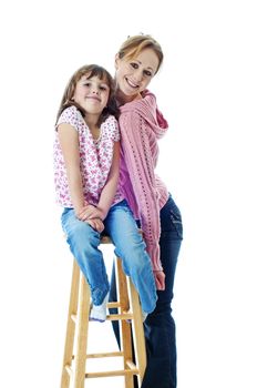 Cute little girl poses with her pretty aunt agaisnt a white background.