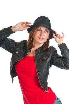 Pretty young woman wearing a leather jacket playing with a black fedora hat