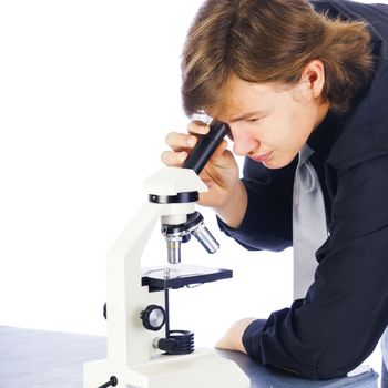 Young college student looking into a microscope in biology lab.