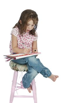 A little girl draws while waiting for her hair to dry after washing it.