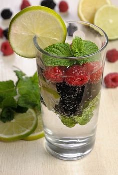 A glass of lemonade from the berries of blackberry and raspberry with lime and mint