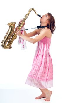 Barefoot girl playing jazz on a tenor saxophone against a white background.