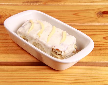 white lasagna isolated on wooden background