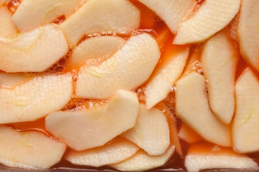 Red wet apple slices within a fruit punch. Food background