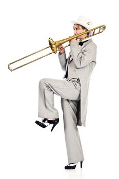 Pretty young woman playing a trombone while wearing tuxedo and top hat.