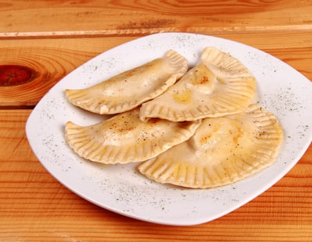 Cooked raviolli on a shiny white plate