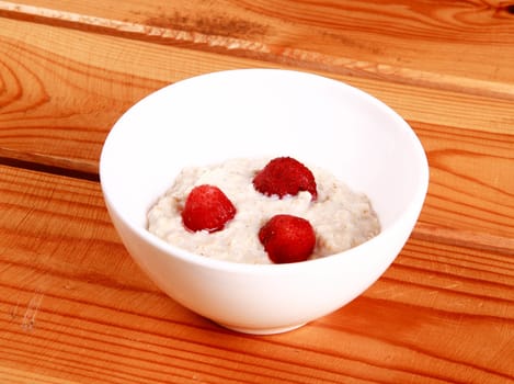 Fresh strawberries in a glass dish on white background.