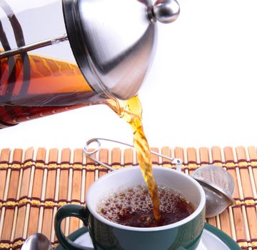 Pouring fresh tea kettle into green cup