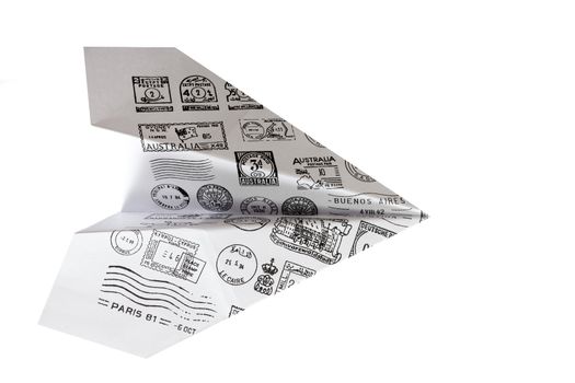 Paper airplane with mail stamps on white background