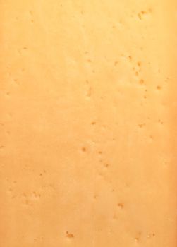 Background of fresh yellow Swiss cheese with holes