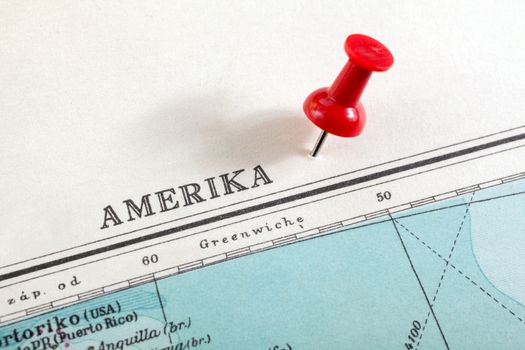 Red push pin showing the location of a destination point on a map. Amerika