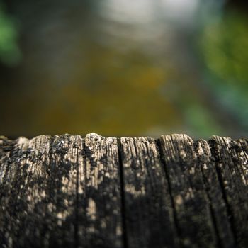 Close-Up Of The Edge Of A Wooden Bridge Over A River With Shallow Depth Of Focus And Copy Space