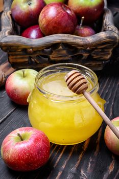 jar of honey and wooden basket of apples