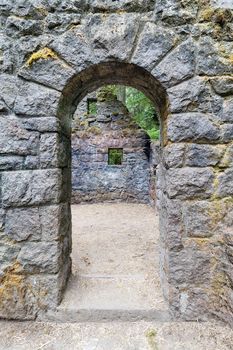 Abandoned stone castle house arch doorway at Wildwood Trail in Forest Park Portland Oregon