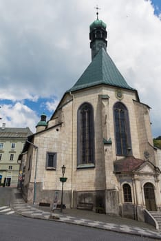 Hill with the Saint Catherine church in Banska Stiavnica, Slovakia. Former mining city, part of the UNESCO World Heritage Site. Intense cloudy sky.