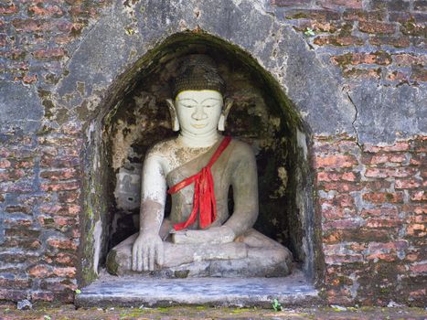 Buddha image in a small niche of an ancient stupa in Mrauk U, Rakhine State in Myanmar.