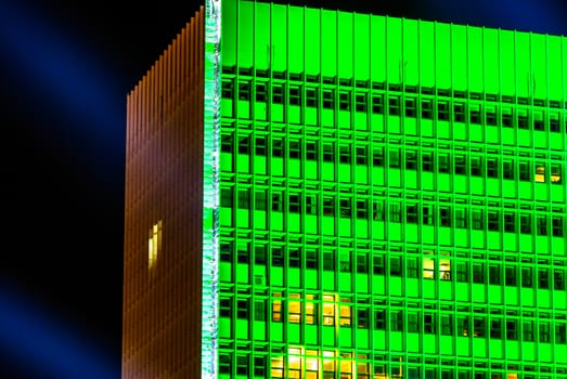 horizontal image of a building with green lights at night