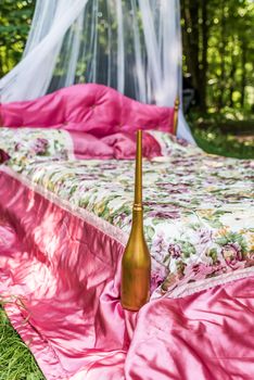 Bed with red blanket in the garden for lovers