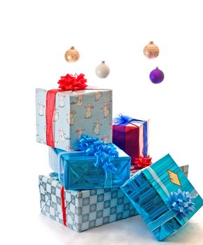 Stack of presents under floating Christmas ornaments