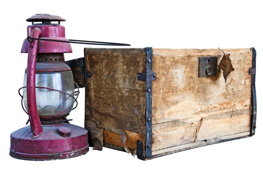 Worn old wooden chest and weathered kerosene lantern isolated on white with a clipping path