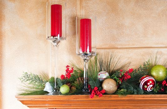 Fireplace mantle decorated with candles and garlands for Christmas