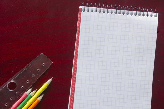 Pencils and ruler on red wooden table