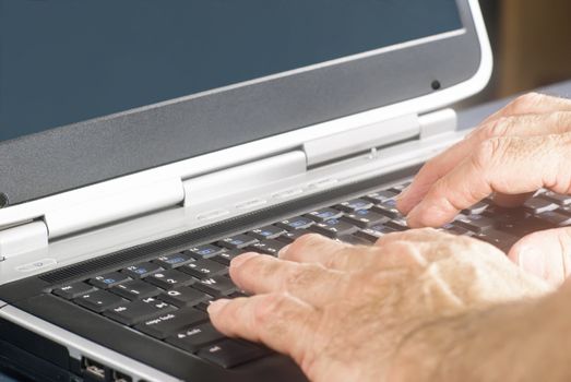 Hands typing on a flat laptop computer keyboard.