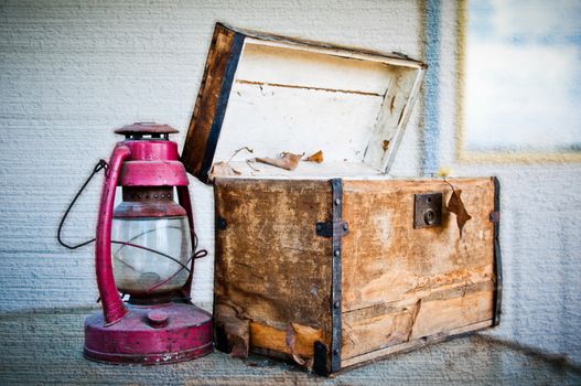 Worn out chest and old lantern on a textured background 