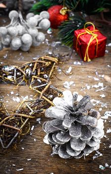 Painted pine cone and Christmas decorations with fir branch