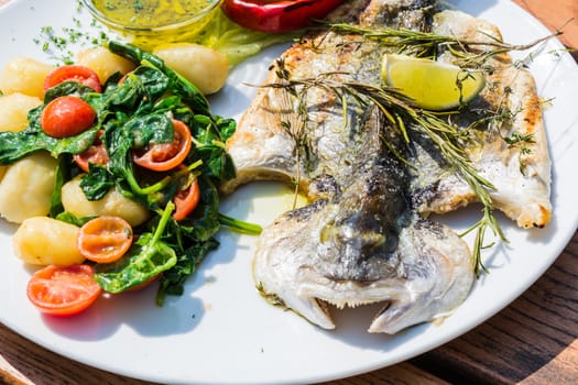 Fresh fish sea bream, bream with salt, herbs and pepper prepares grilled.