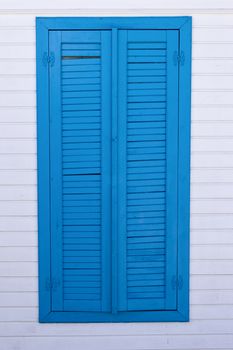 Single blue window on white wooden wall