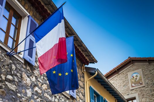 French and European flags hanged on an ancient city hall at french riviera