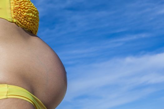 8 months pregnant woman with yellow swimsuit