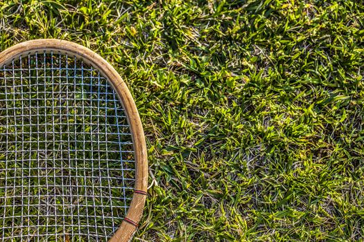 Vintage wood tennis racket on grass garden