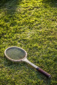 Vintage wood tennis racket on grass garden