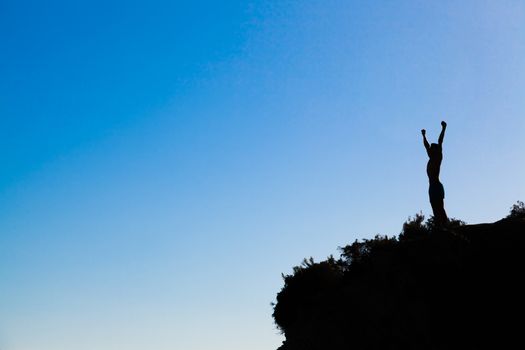man on top of the mountain reaches for the glory at the sunset