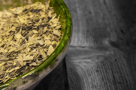 Dried green tea leaves in a green  glass jar