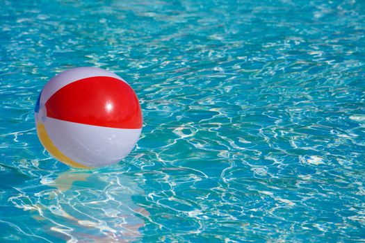 Inflatable colorful ball floating in a swimming pool