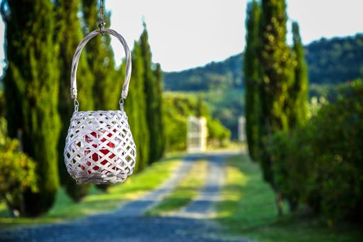 A modern red candel in a classic lantern in a tuscany hill