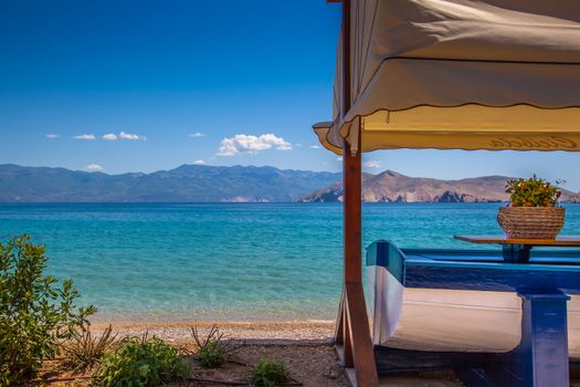 A boat used as a table in front of a suny tropical beach