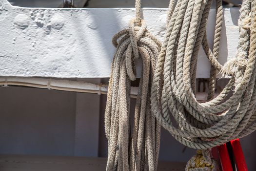 Hanged weathered boat ropes on a blue sea